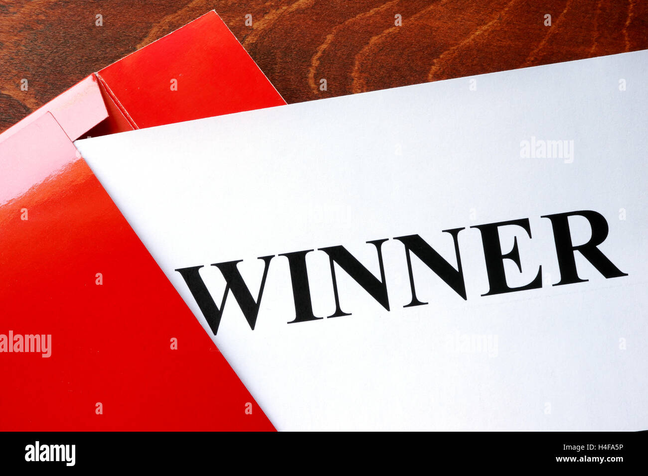 Paper with word winner and red envelope. Stock Photo