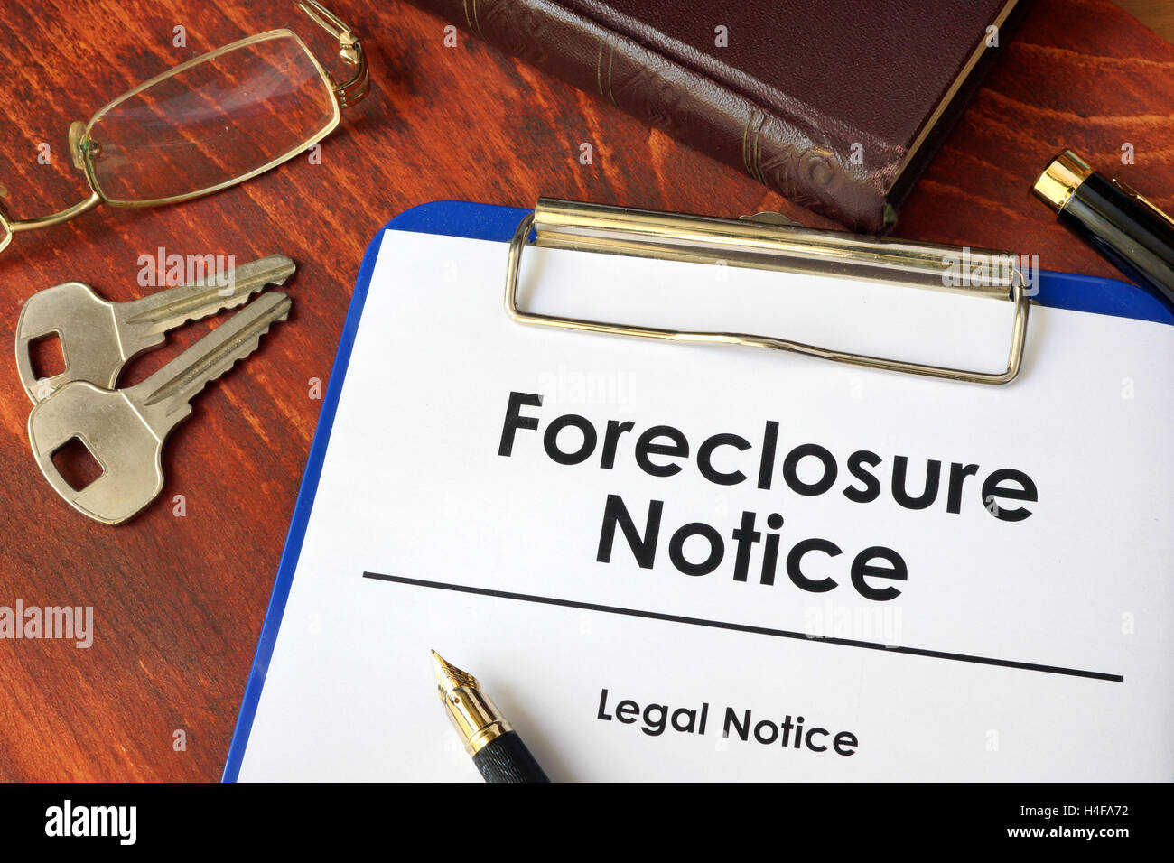 Paper with words Foreclosure Notice on a wooden surface. Stock Photo