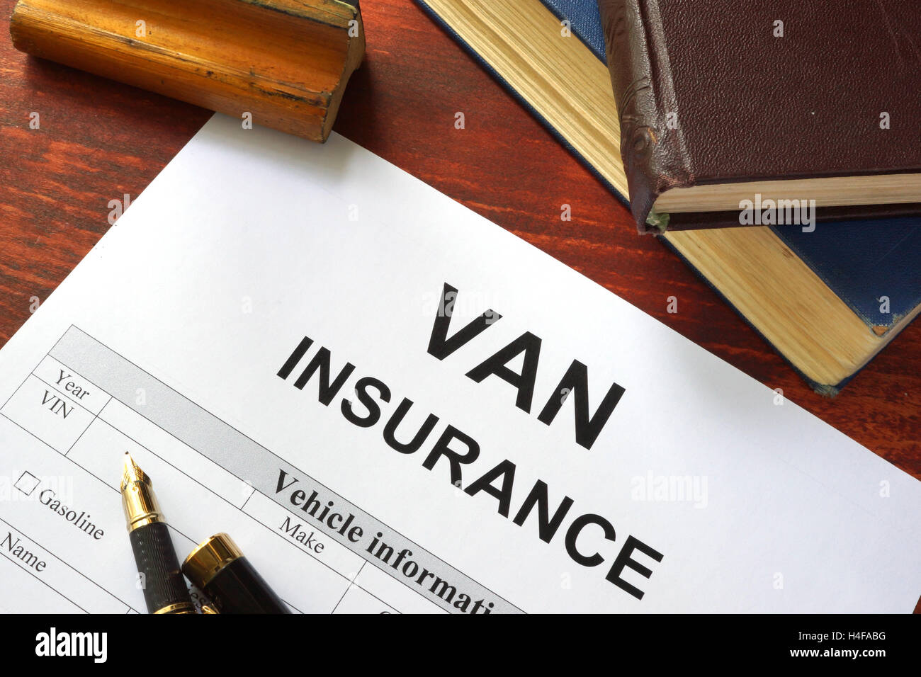 VAN insurance form on a table with a book. Stock Photo