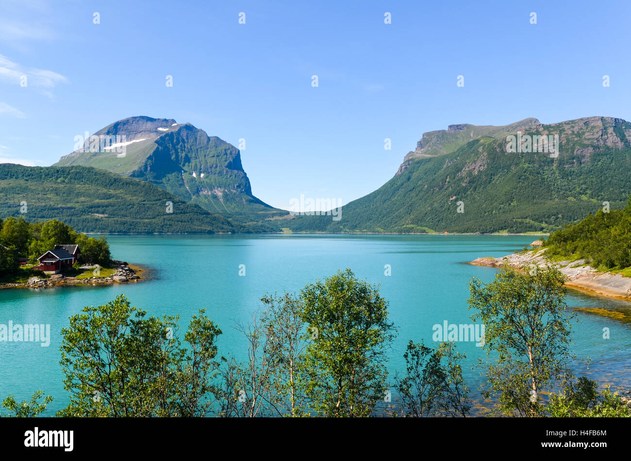 Cabin by the turquoise waters of Glomfjord, Northern Norway Stock Photo