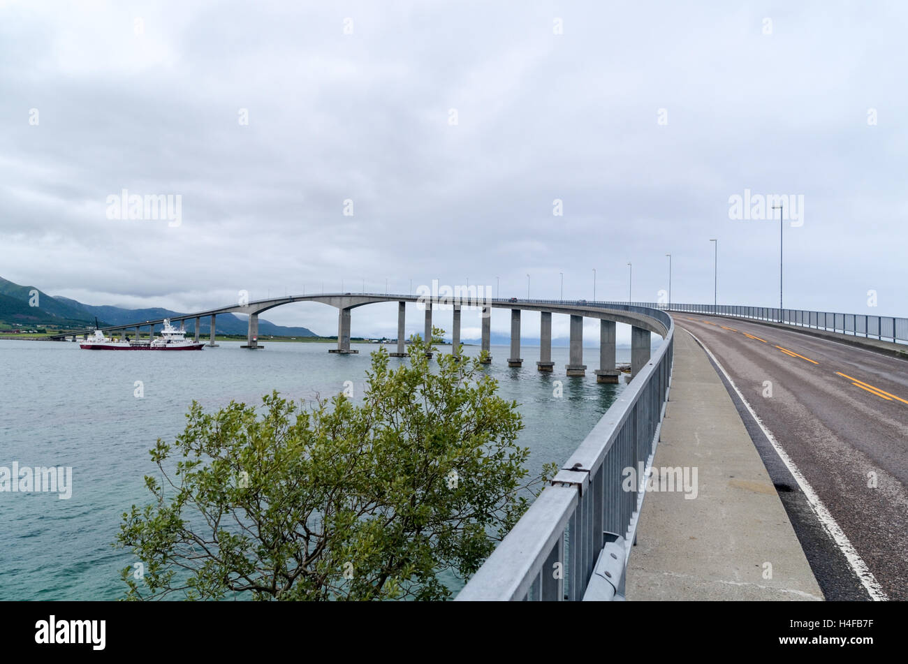 Barge/ship passing under a high bridge in Norway on Langøya, Vesterålen ...
