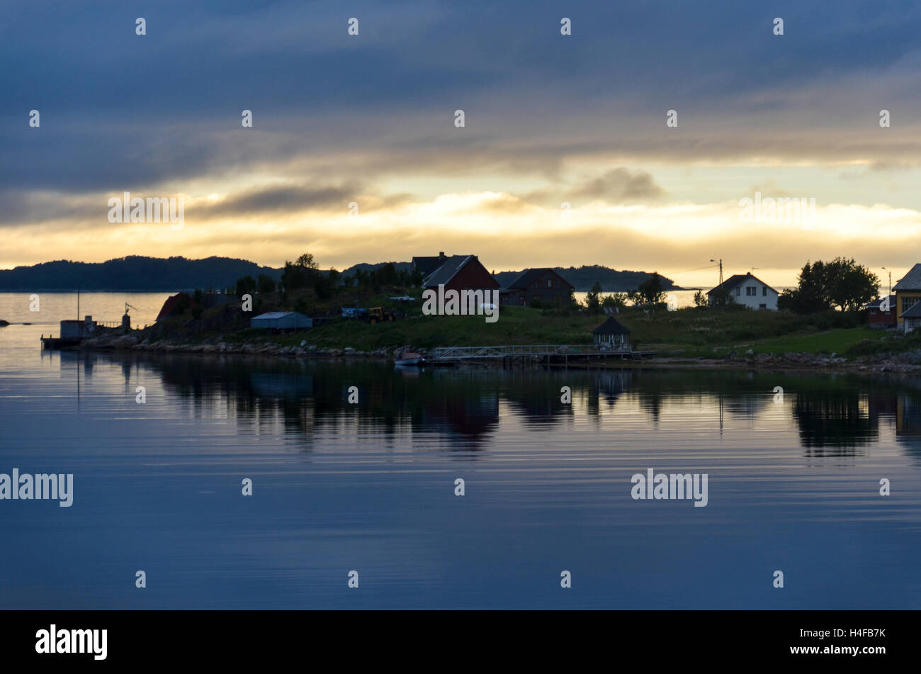 Cloudy sunset at midnight over a few houses on the island of Senja, Northern Norway Stock Photo