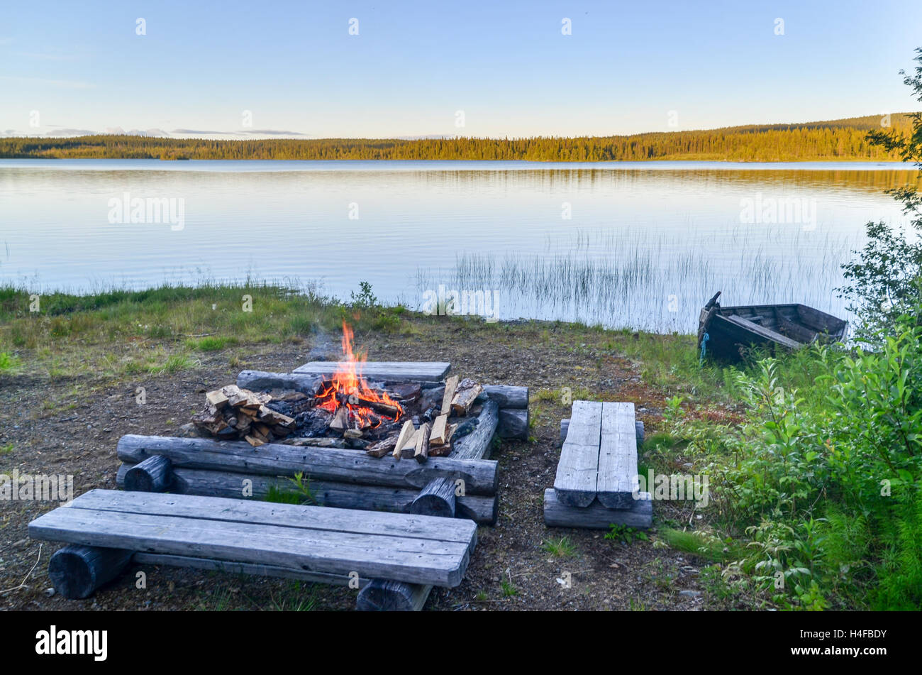 Fire and benches by a lake in Sweden Stock Photo