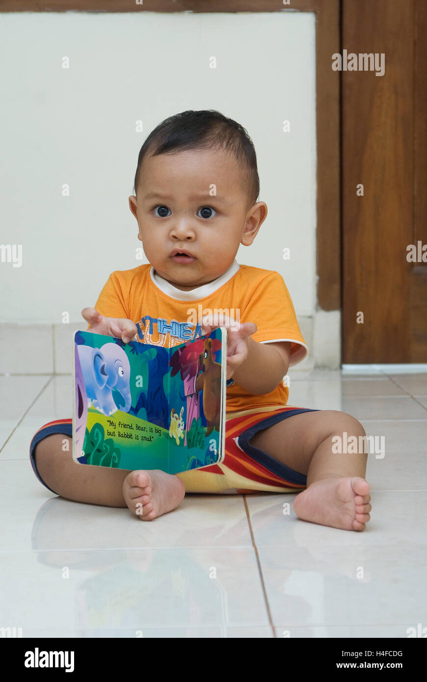 a kids, toddler, learning, playing with animal book,  happy face Stock Photo