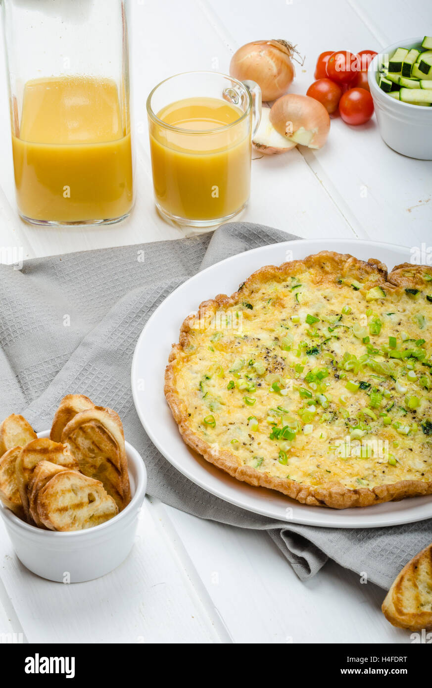 Omelette with zucchini and mozzarella cheese, scallions, fresh orange juice and crispy toast Stock Photo
