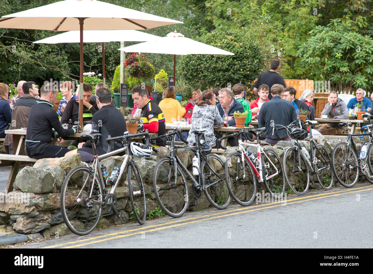 Cyclists at a cafe in the attractive village of Beddgelert, Snowdonia National Park, North Wales, UK Stock Photo