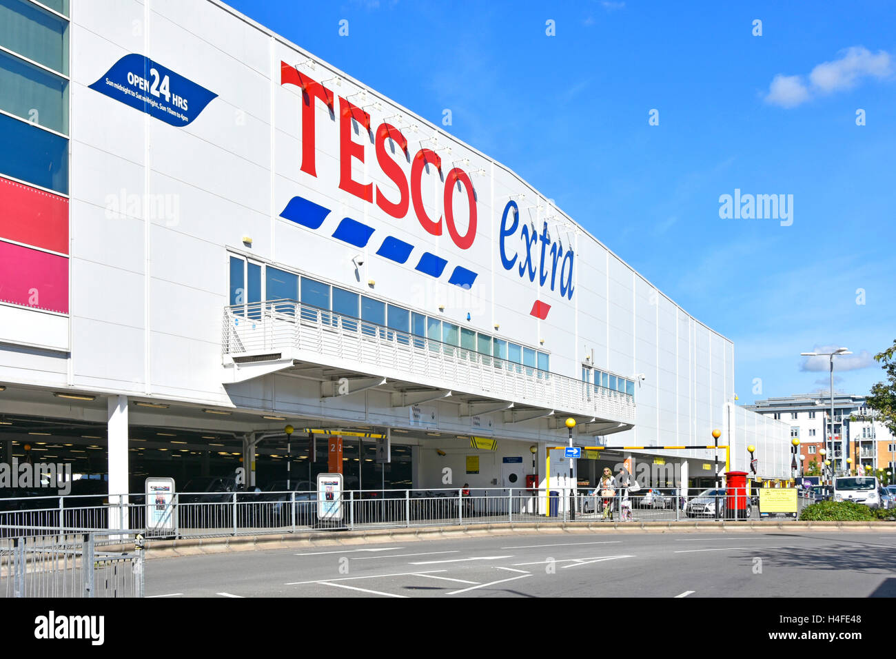 English Tesco Extra store and 24 hour shopping signs above ground floor covered customer car park for large uk supermarket in Slough town Berkshire uk Stock Photo