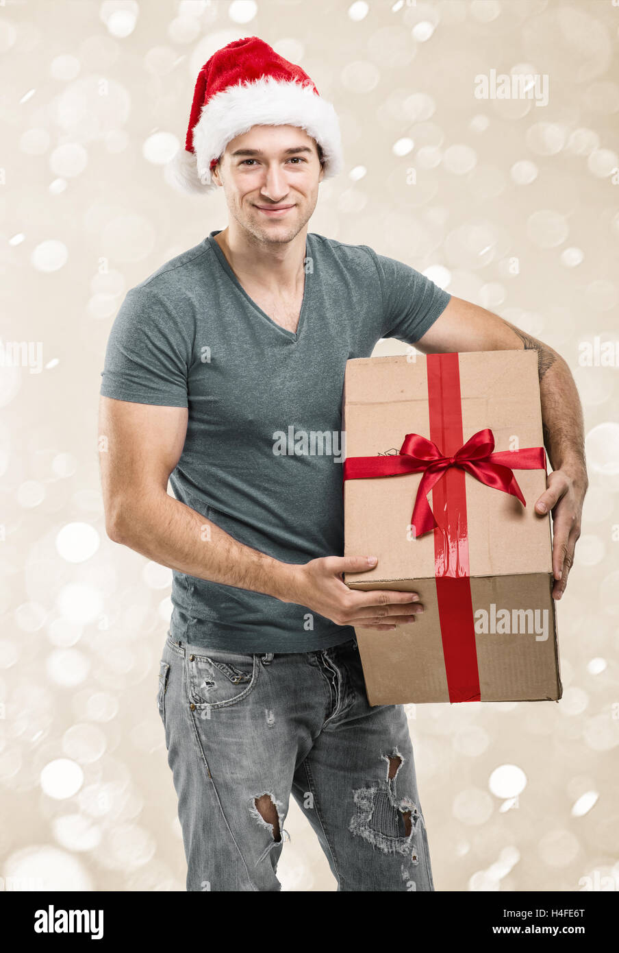 Handsome man in santa hat - hand gift box Stock Photo
