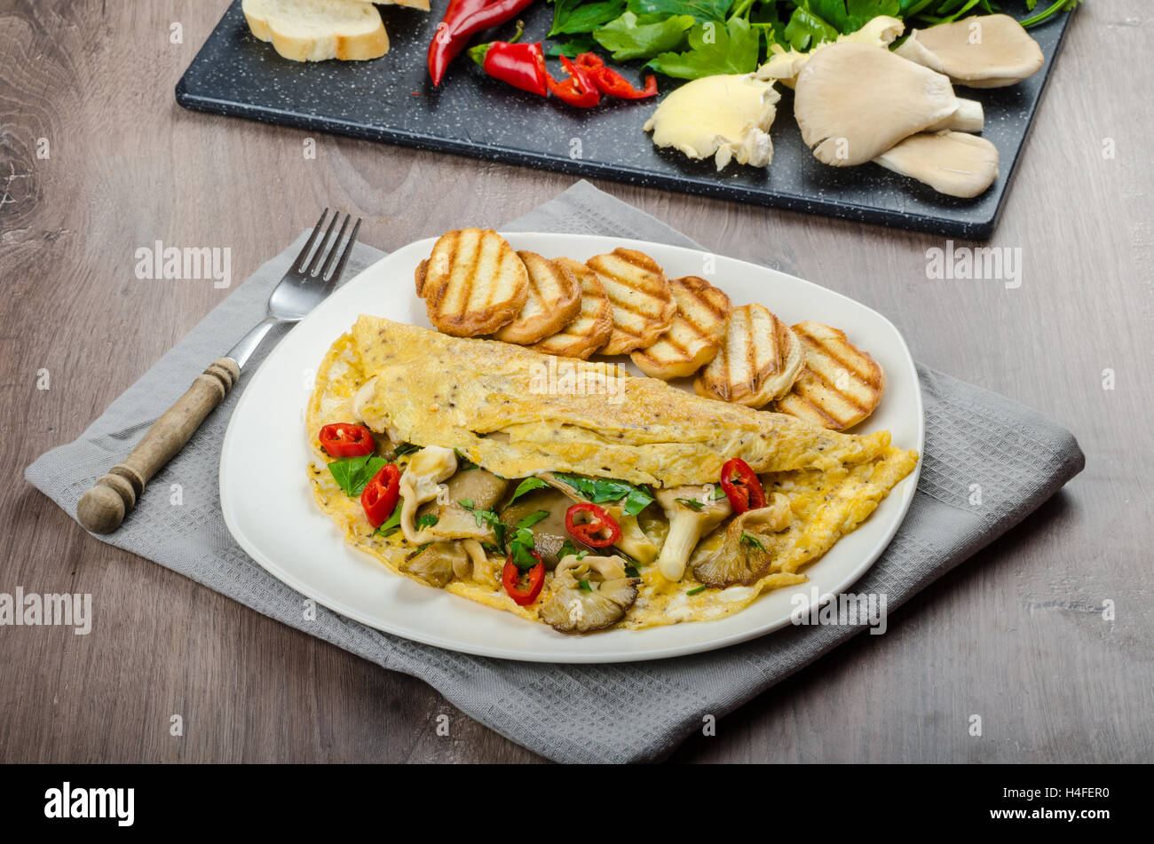 Rustic vegetarian omelette with chili peppers and mushrooms Stock Photo