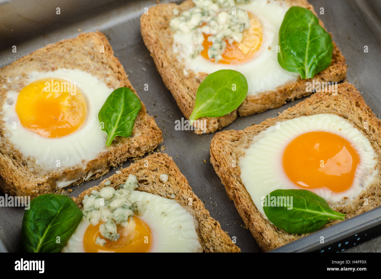 Baked Bull'sEye Eggs on whole wheat toast with spinach and blue cheese