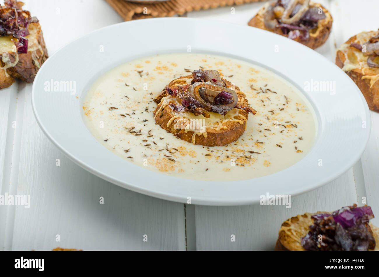 Creamy onion garlic soup, toast with melted cheese and caramelized
