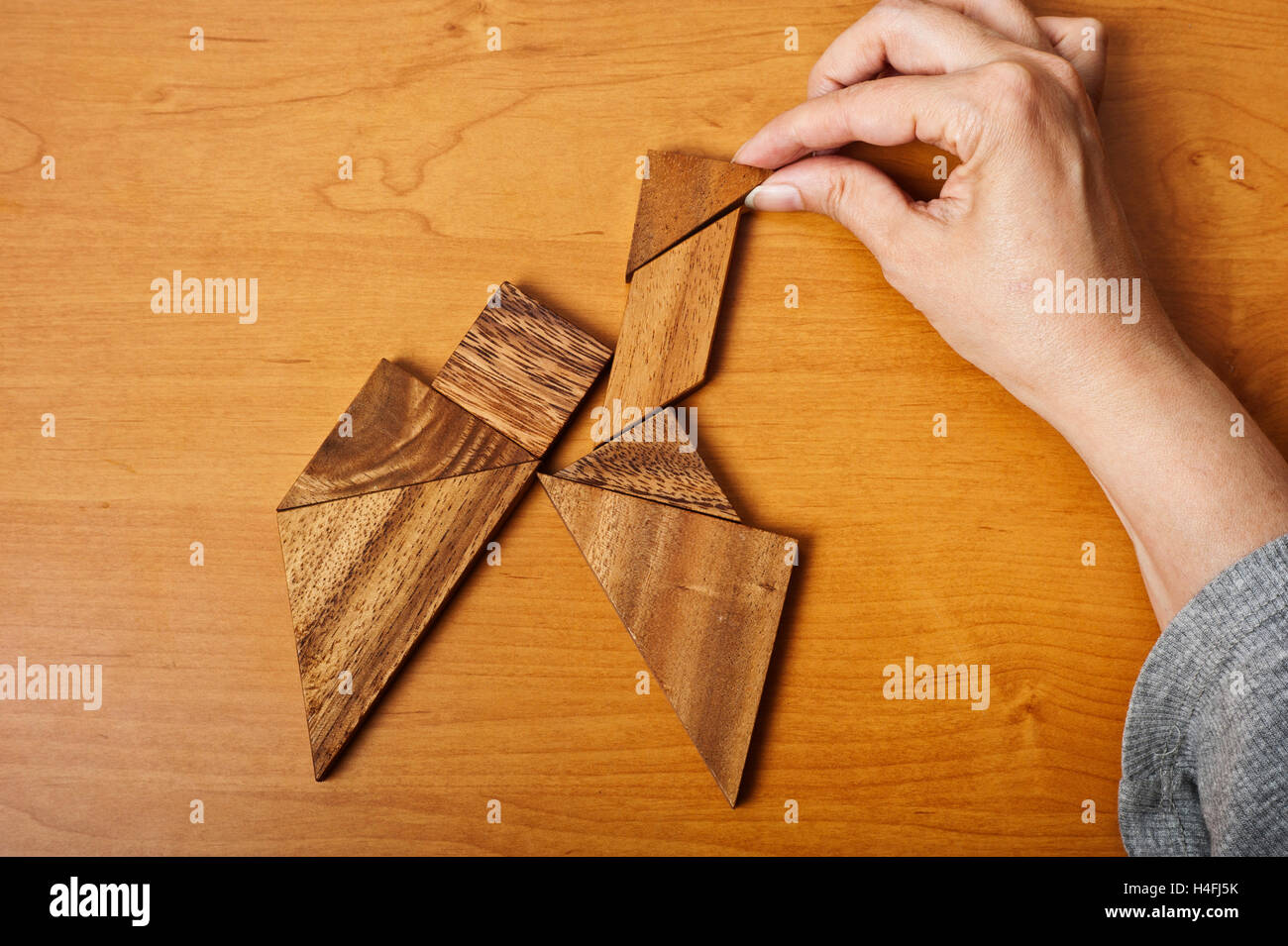 hands of a woman playing the game of Tangram Stock Photo