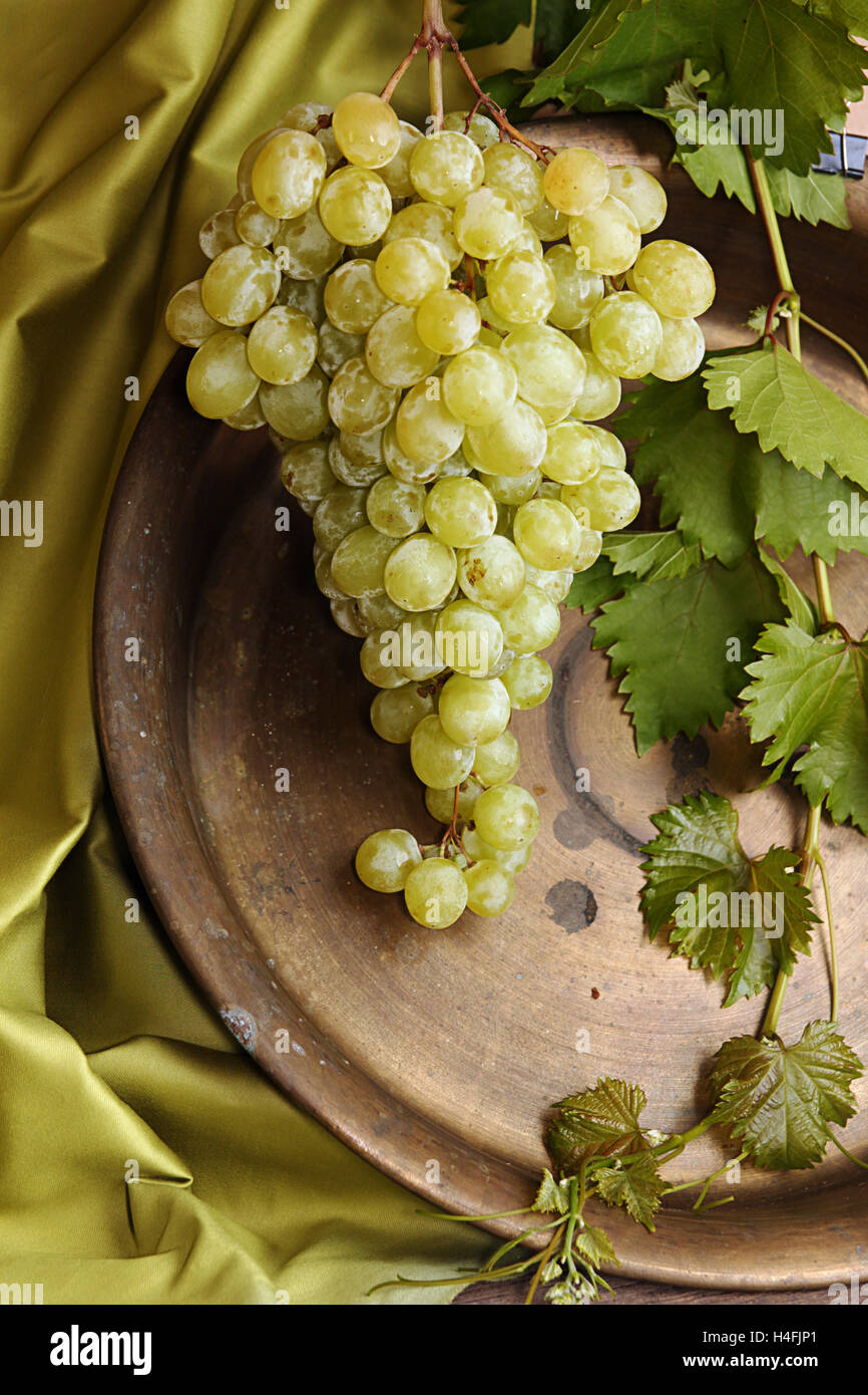 Cluster of sweet and tasty organic green grapes against old copper