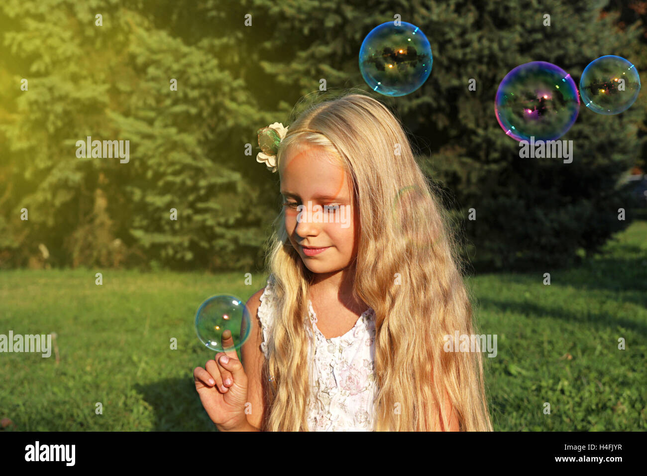 Girl in park with bubbles on green grass Stock Photo - Alamy