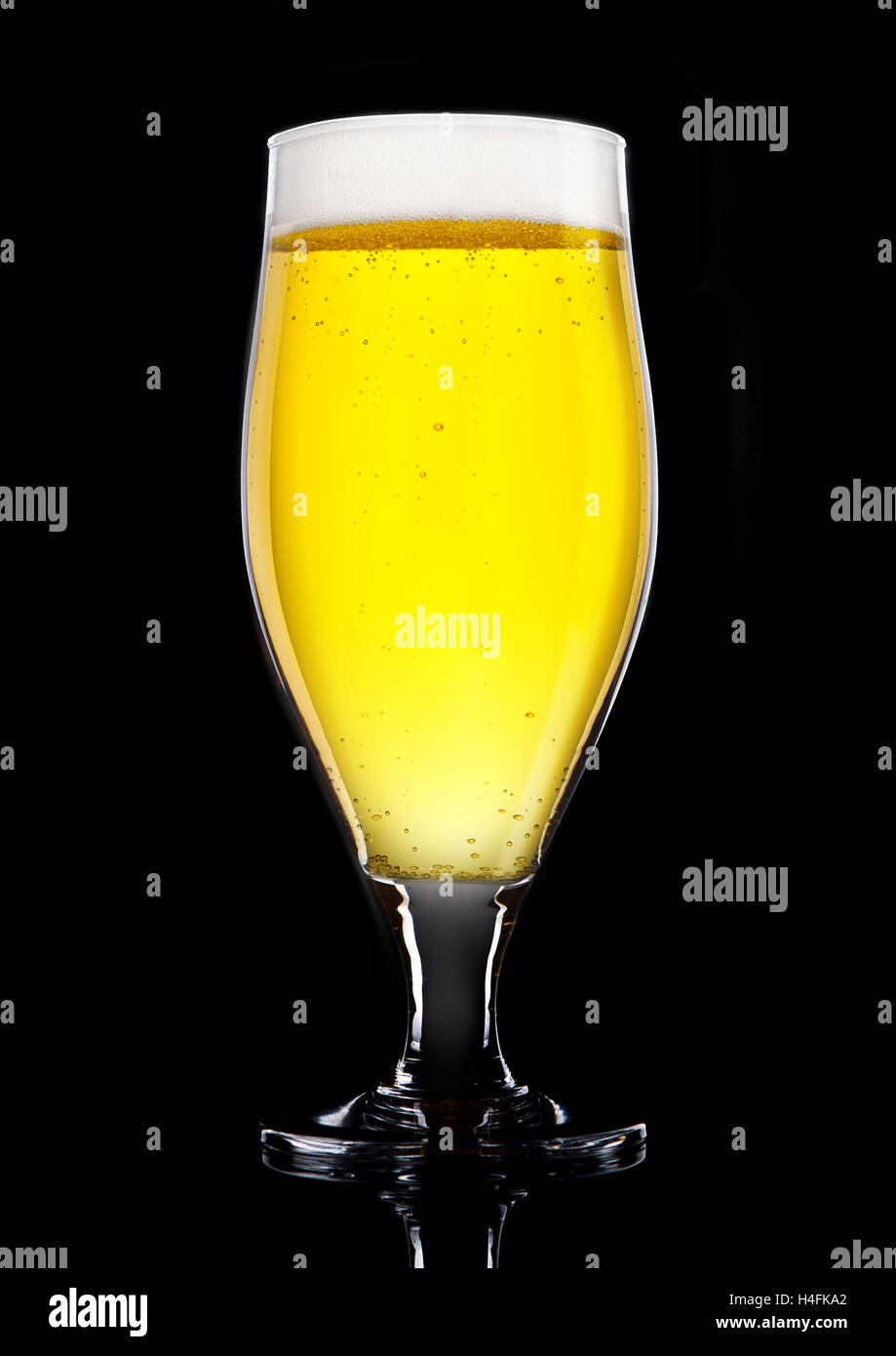 Glass of beer cider with foam golden color on black background Stock