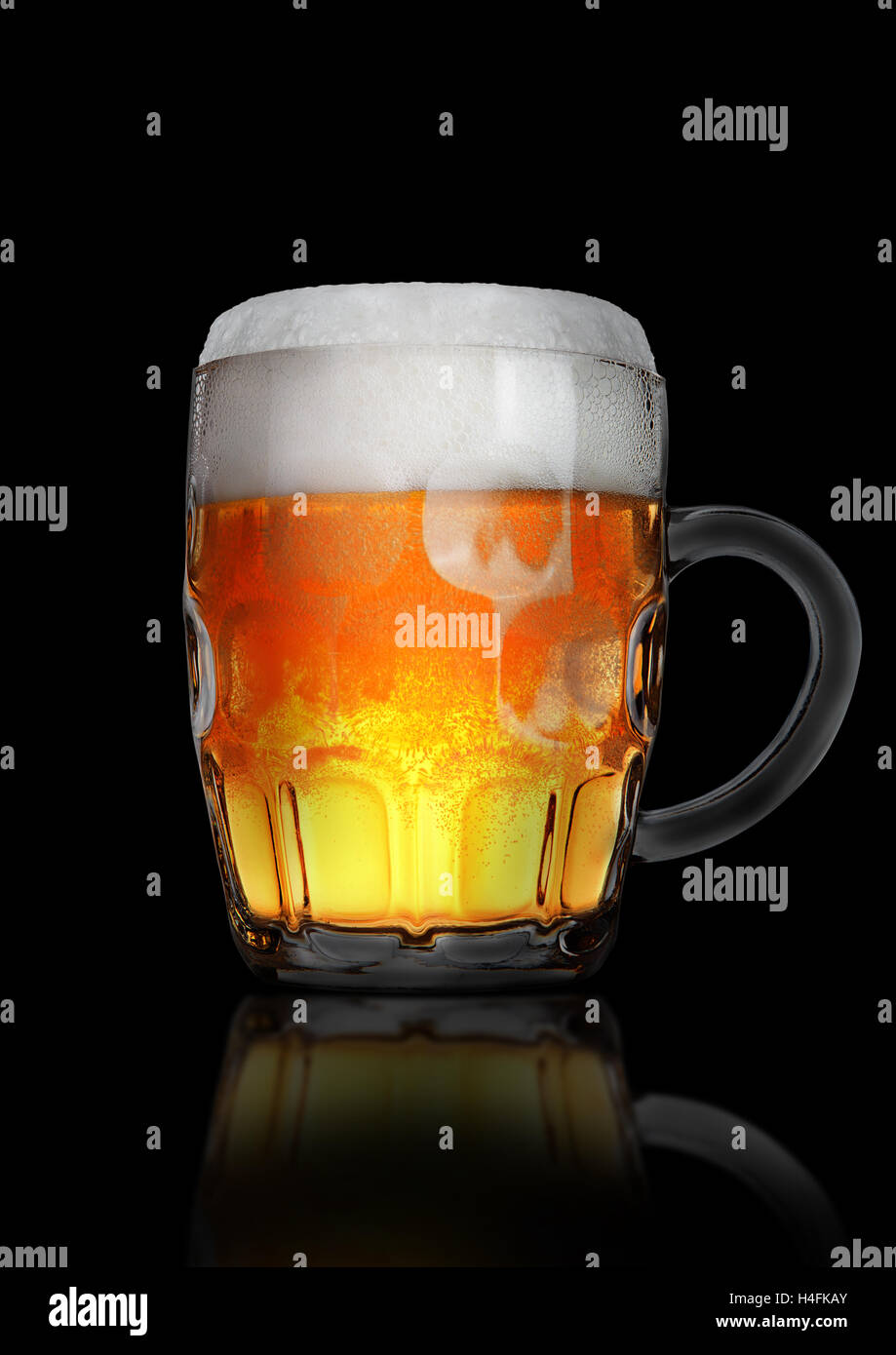 Vintage large glass of beer with foam and bubbles on black background