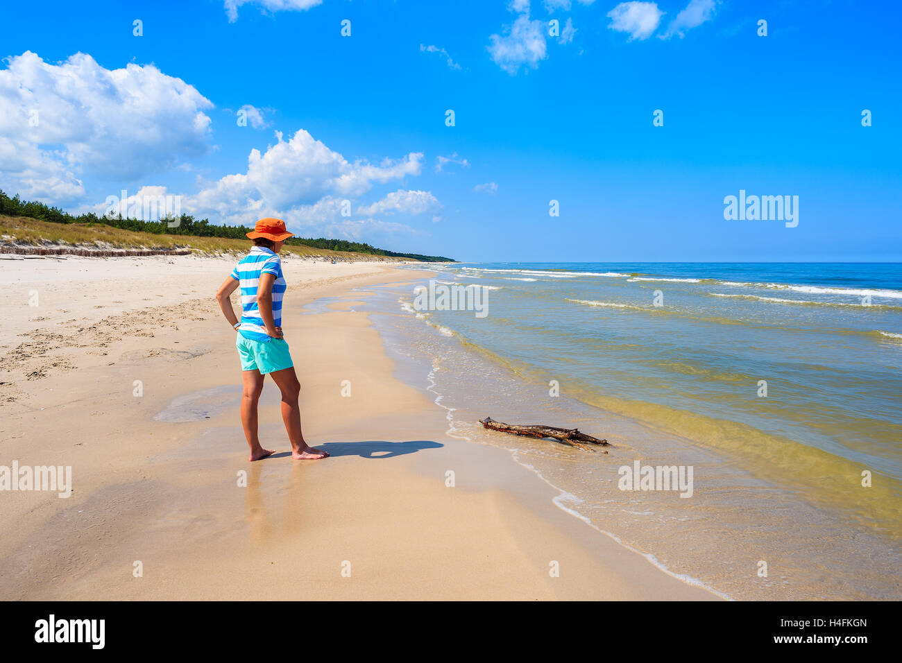 Young woman tourist standing on white sand beach in Bialogora, Baltic Sea, Poland Stock Photo