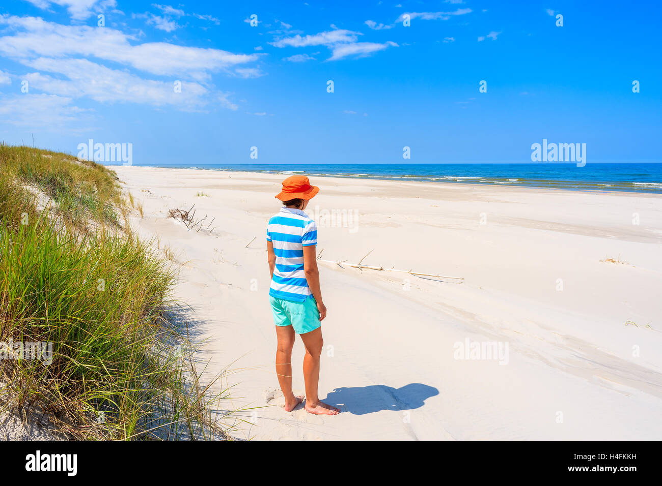 A young woman tourist standing on white sand beach, Baltic Sea, Bialogora coastal village, Poland Stock Photo