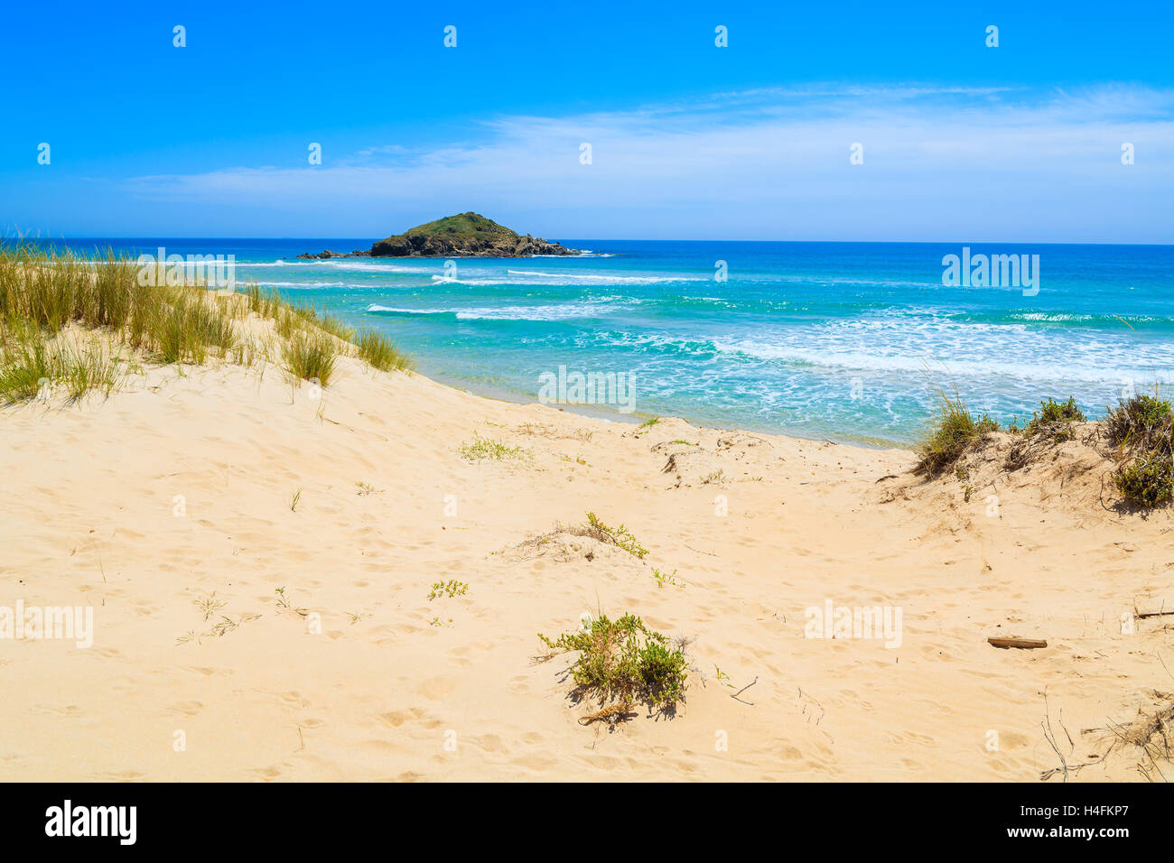 Grass on sand dune at Chia beach and turquoise sea view, Sardinia island, Italy Stock Photo