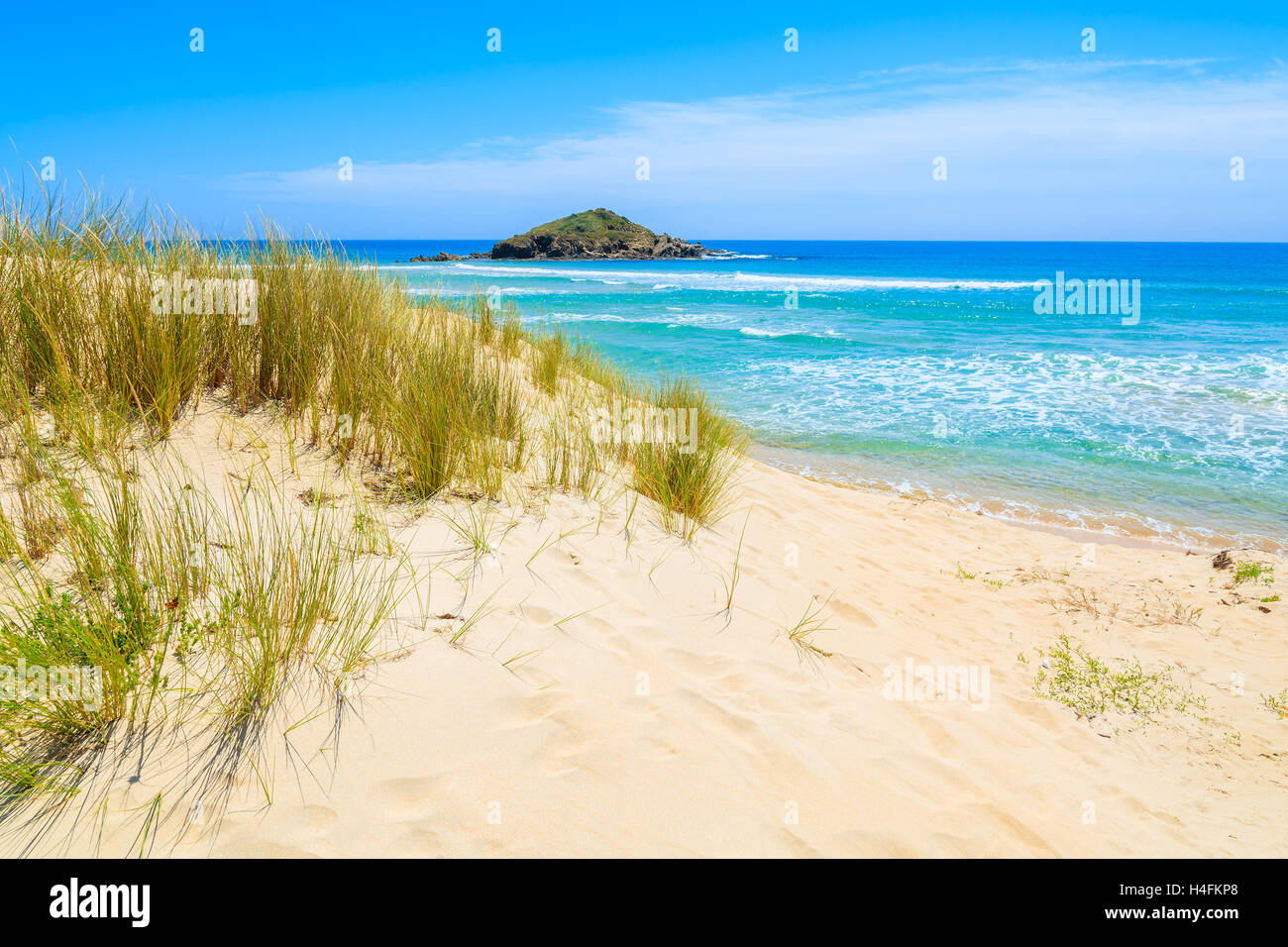 Grass on sand dune at Chia beach and turquoise sea view, Sardinia island, Italy Stock Photo