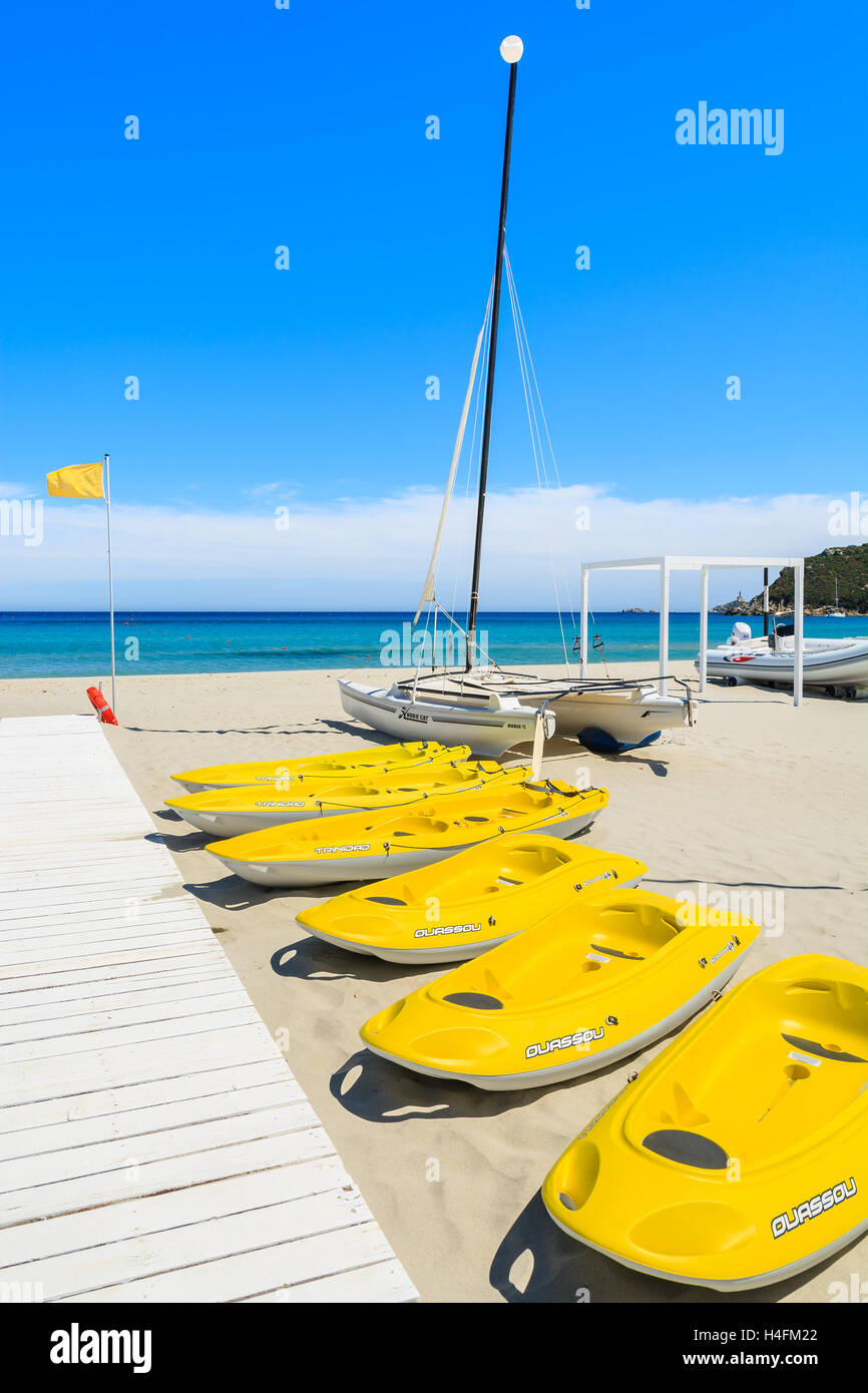 PORTO GIUNCO BEACH, SARDINIA - MAY 27, 2014: yellow kayaks and catamaran boats on Porto Giunco beach, Sardinia island, Italy Stock Photo