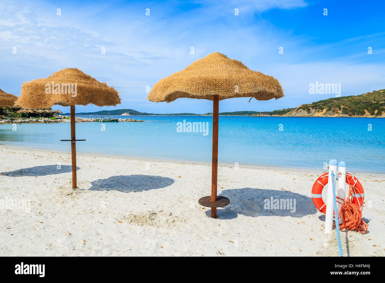Umbrellas on Punta Molentis beach and red life ring with rope, Sardinia island, Italy Stock Photo