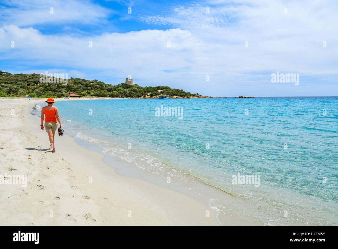 Young woman tourist walking on beach at Cala Pira bay, Sardinia island, Italy Stock Photo