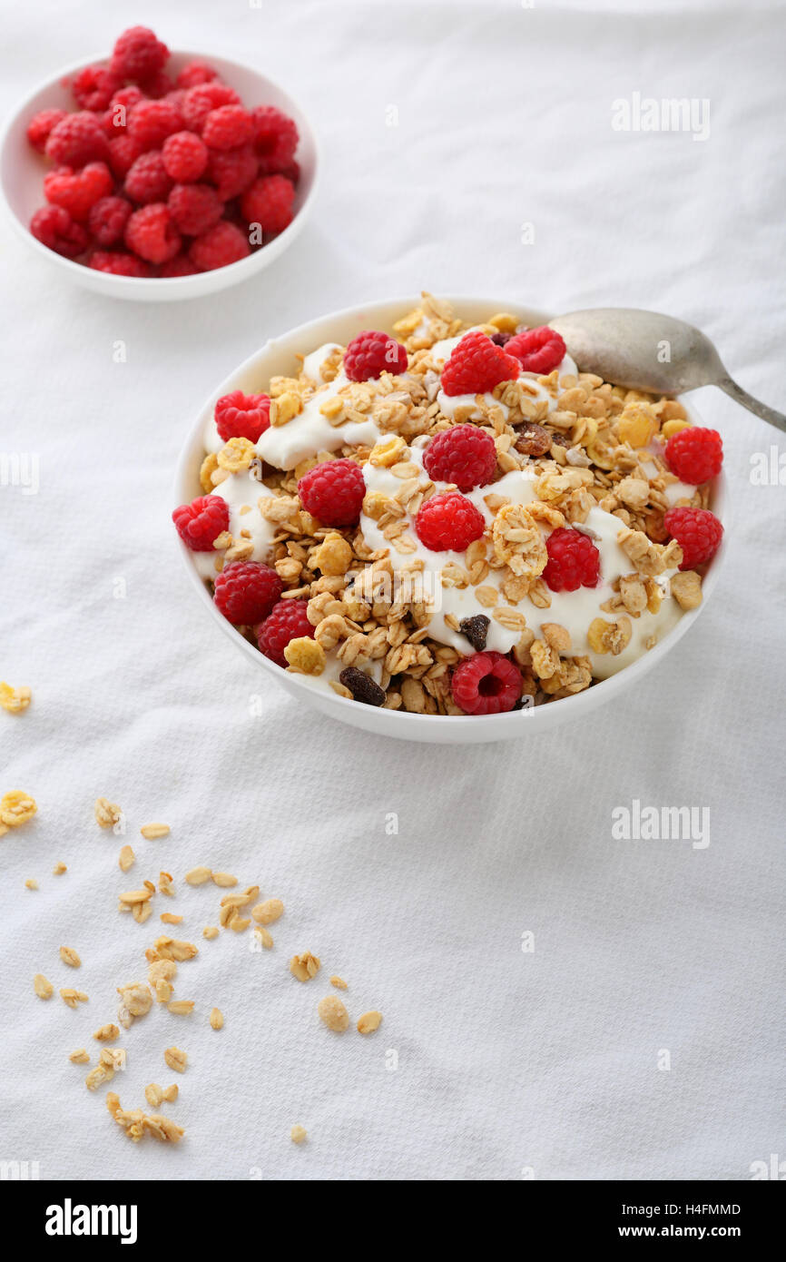 Breakfast muesli with raspberry and yogurt, food closeup Stock Photo