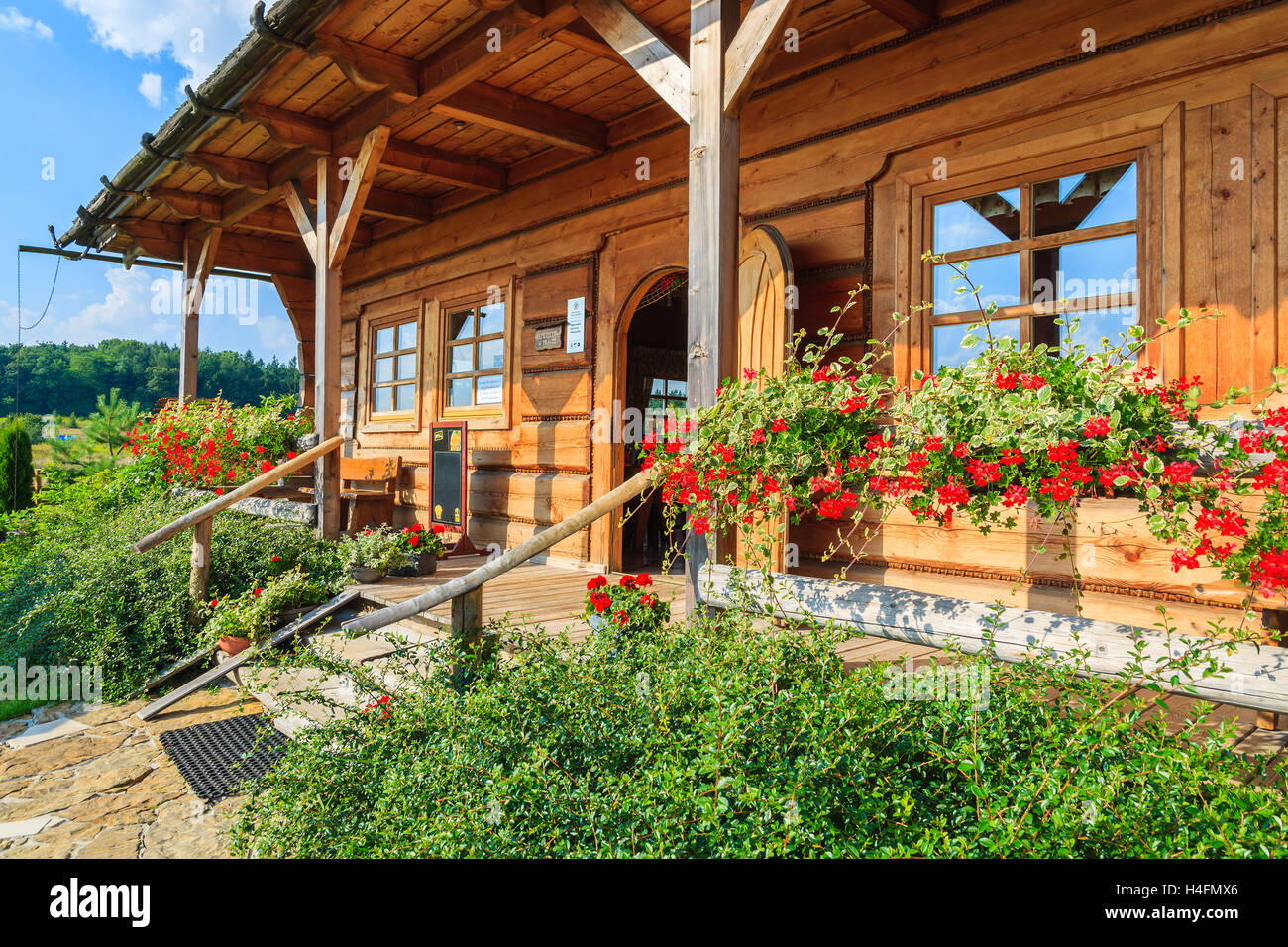 VILLAGE NEAR KRAKOW, POLAND - AUG 9, 2014: front view of traditional restaurant building on sunny summer day. Mountain style architecture is very popular in south of Poland. Stock Photo