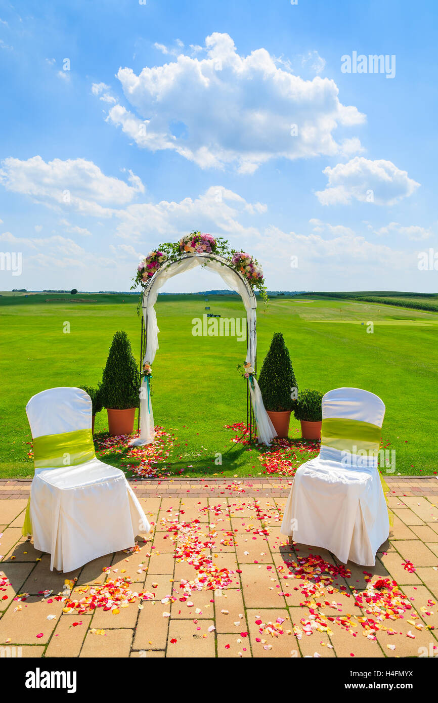 Arch and two white chairs in golf club prepared for weeding ceremony, Poland Stock Photo