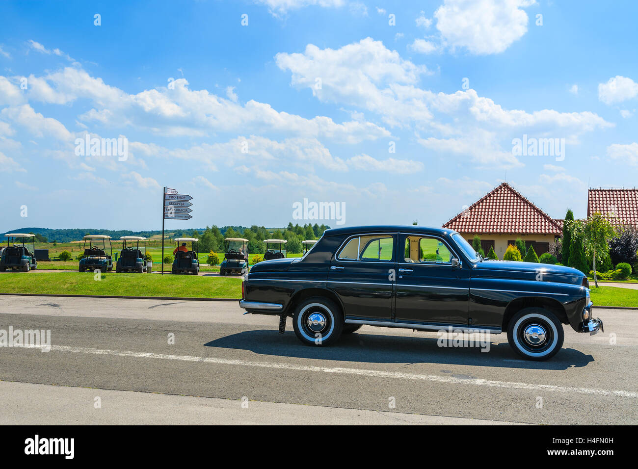 PACZULTOWICE GOLF CLUB, POLAND - AUG 9, 2014: old classic black car parks on street in Paczultowice Golf Club. Vintage cars are popular to drive people to weeding ceremony. Stock Photo
