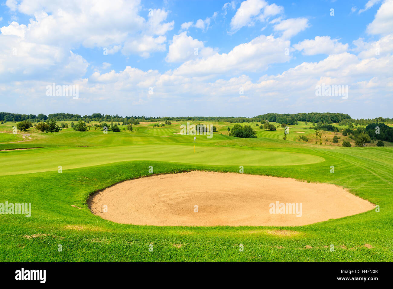 PACZULTOWICE GOLF CLUB, POLAND - AUG 9, 2014: golf course green play area in Paczultowice village on sunny summer day, Poland. Golfing is becoming a popular sport among wealthy people from Krakow. Stock Photo