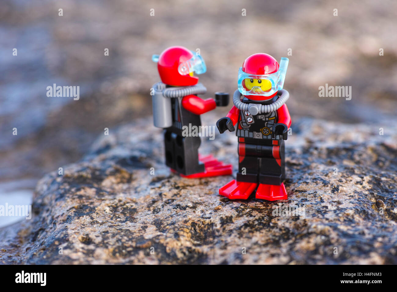 Paphos, Cyprus - October 09, 2016 Two Lego scuba divers minifigures standing on sea stones. Stock Photo