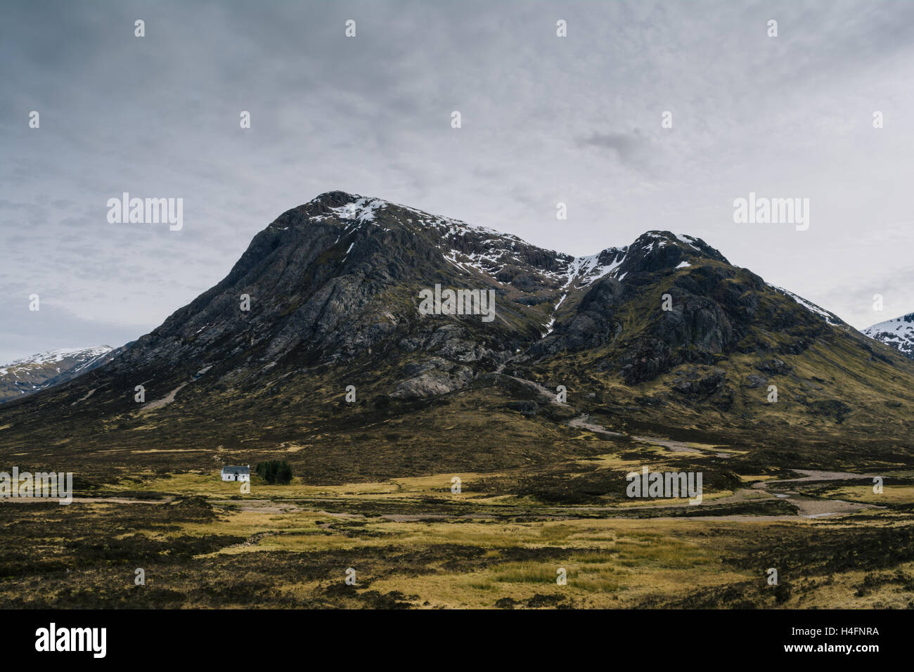 A traditional But and Ben (Cottage) with a mountainous backdrop in the Scottish Highlands UK Stock Photo
