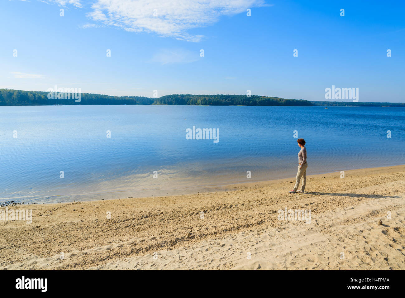 Young woman standing on sandy shore of Chancza lake, Poland Stock Photo