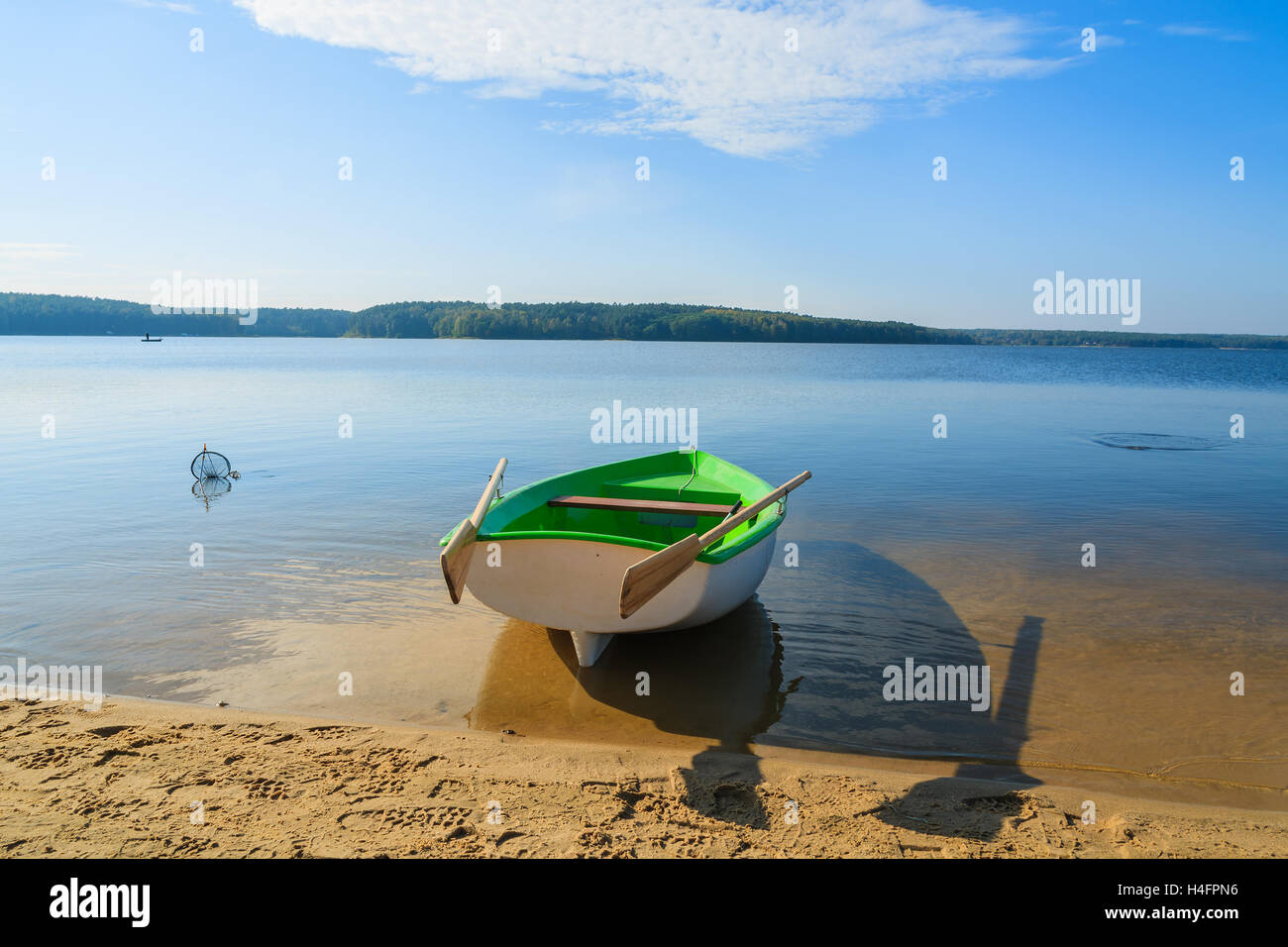 Fishing boat on shore of Chancza lake in warm afternoon light, Poland Stock Photo