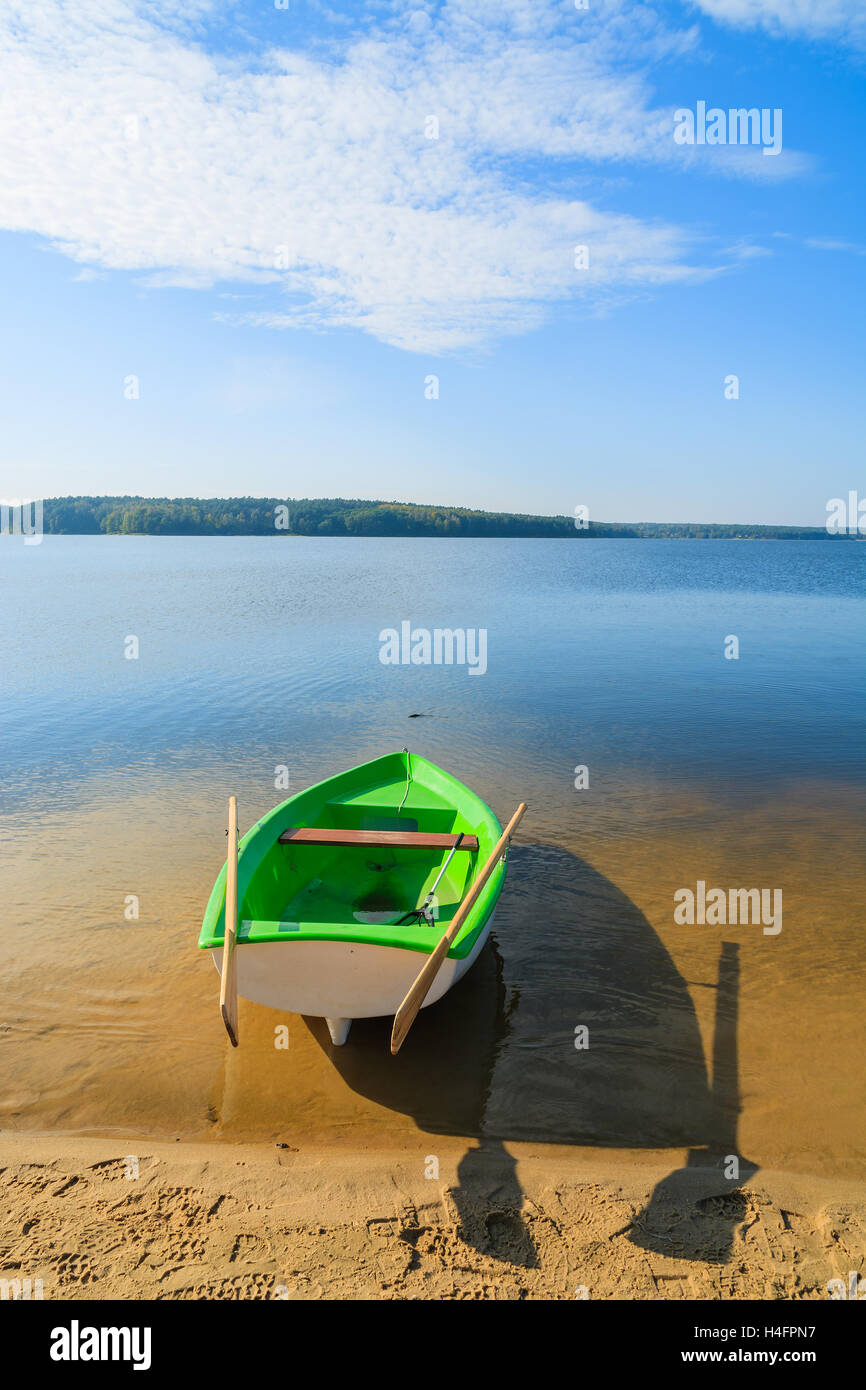 Fishing boat on shore of Chancza lake in warm afternoon light, Poland Stock Photo