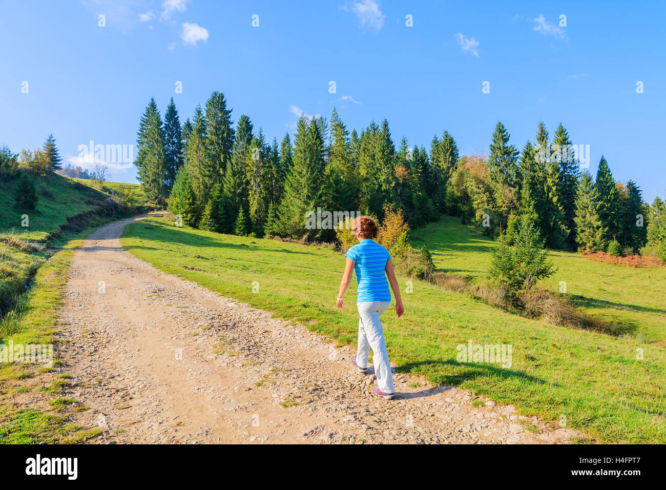 Young woman tourist walking on mountain path in Pieniny Mountains on sunny autumn day, Poland Stock Photo