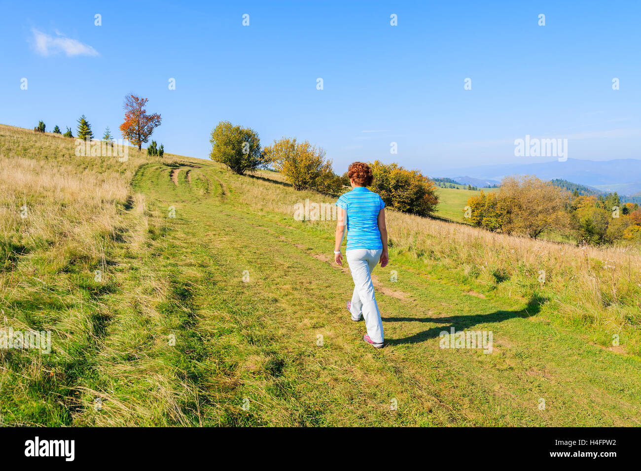 Young woman tourist walking on mountain path in Pieniny Mountains on sunny autumn day, Poland Stock Photo
