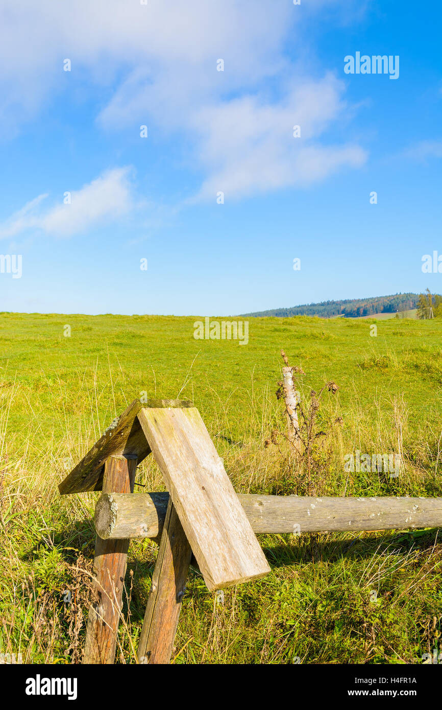Wooden fence on green field on sunny day, Beskid Niski Mountains, Poland Stock Photo