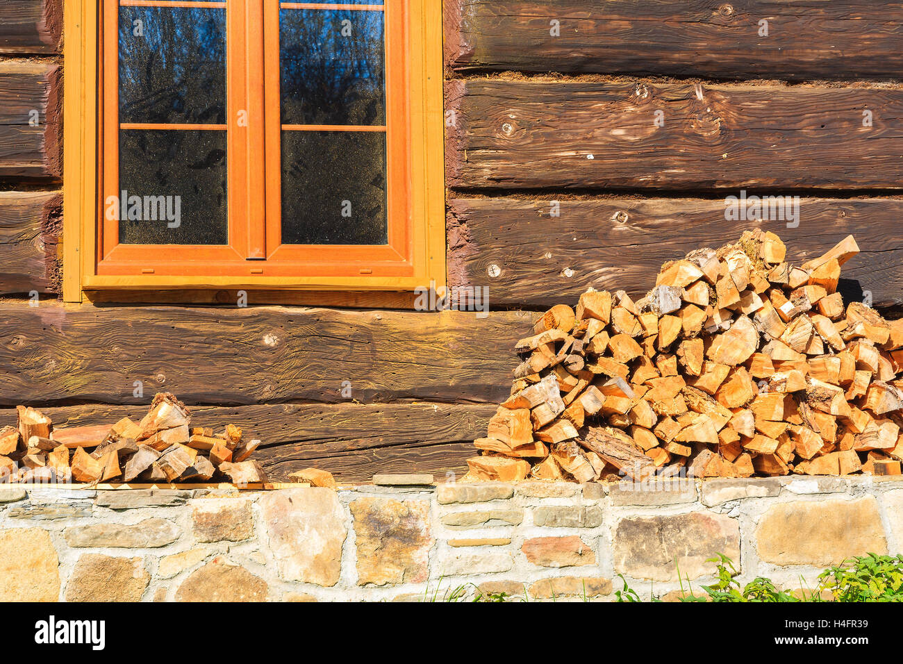 Pile of firewood stacked up in front of a house in Beskid Niski Mountains, Poland Stock Photo