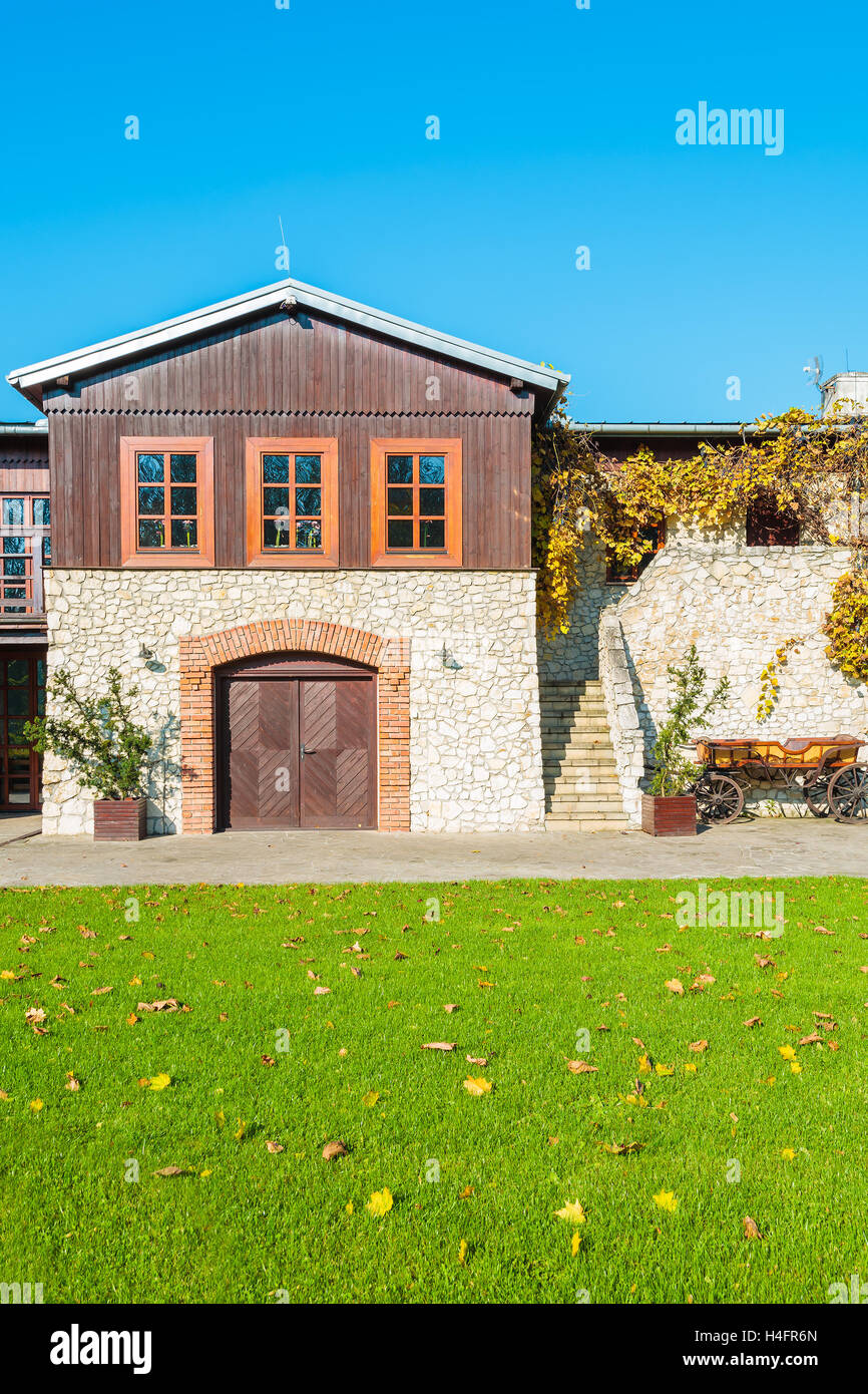 Green lawn and traditional house in Tomaszowice village park on sunny autumn day, Poland Stock Photo