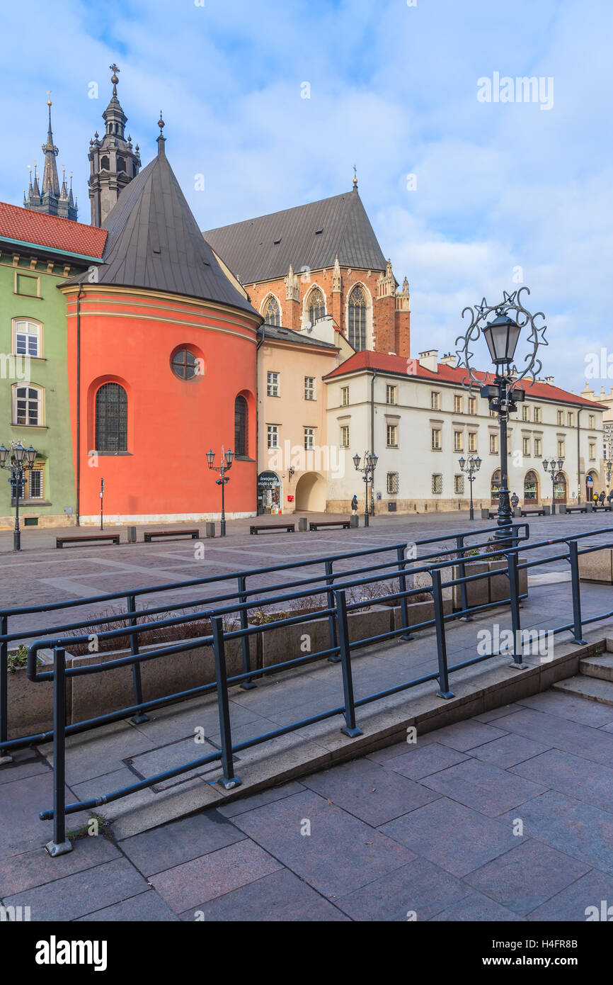 KRAKOW, POLAND - DEC 10, 2014: Mariacki church and colourful houses on square in Krakow. Many tourists visit Krakow which is most popular destination in Poland. Stock Photo