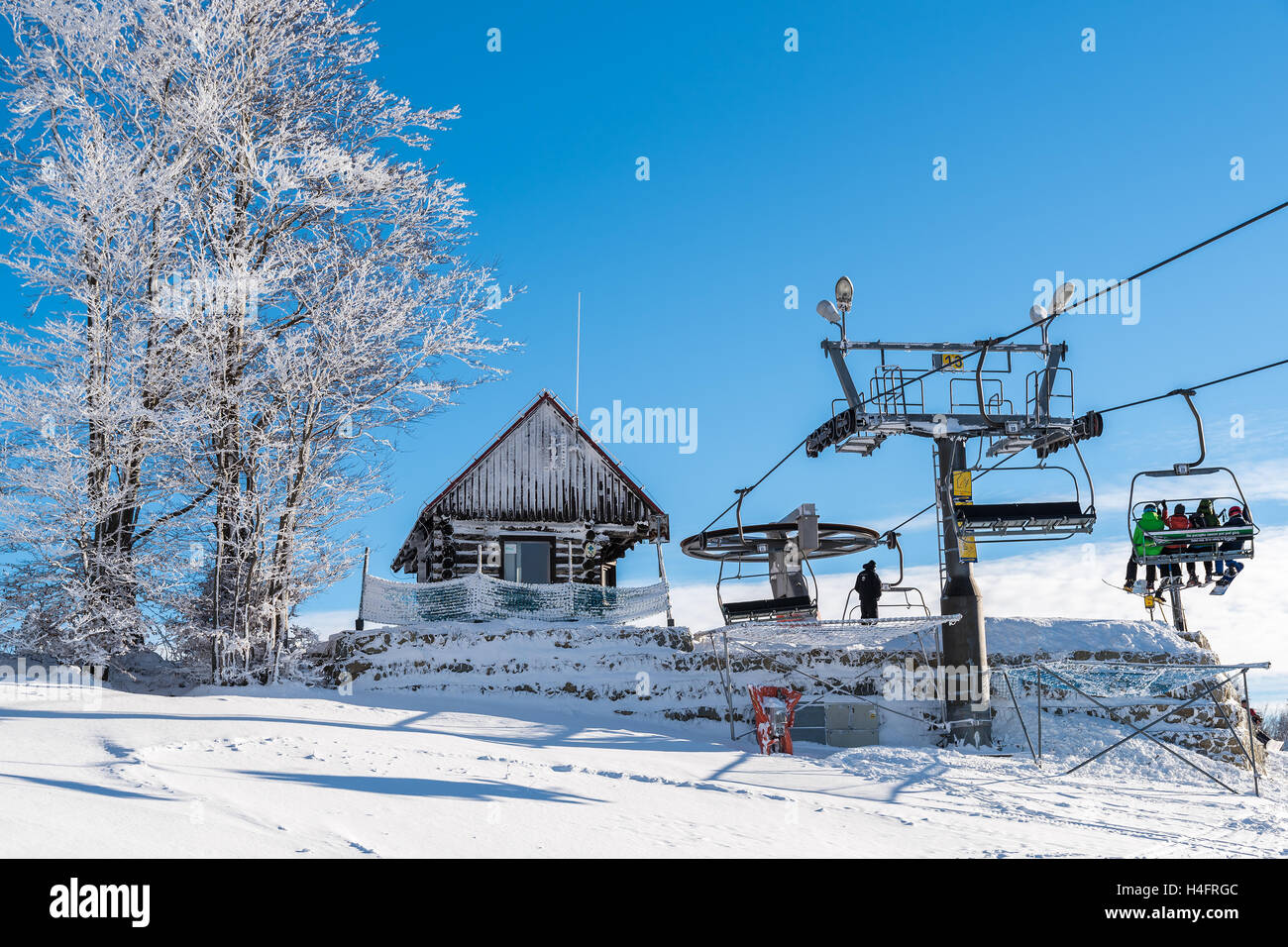 WIERCHOMLA SKI RESORT, POLAND - DEC 31, 2014: ski lift and slope in winter landscape of Beskid Sadecki Mountains. Skiing is popular sport in southern Poland. Stock Photo