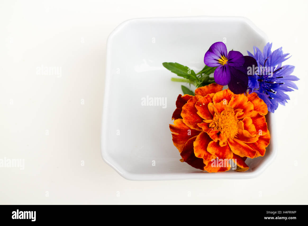 Edible flowers, calendula, pansy, bachelor button in a container, use