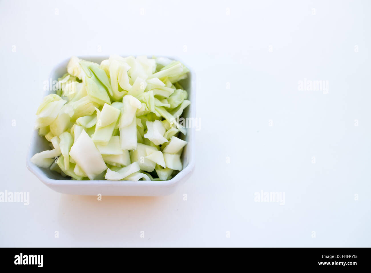 Green cabbage chopped up in a bowl ready to be used, food inspired Stock Photo