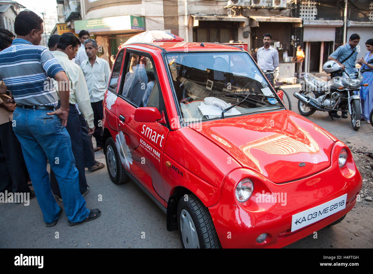 Red eco environmentally friendly small,micro,Reva smart mini,micro,car ,in street near Indian Stock Market,Mumbai,Maharashtra,India,Asia. Stock Photo