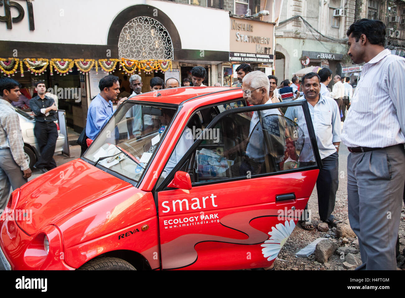 Red eco environmentally friendly small,micro,Reva smart mini,micro,car ,in street near Indian Stock Market,Mumbai,Maharashtra,India,Asia. Stock Photo