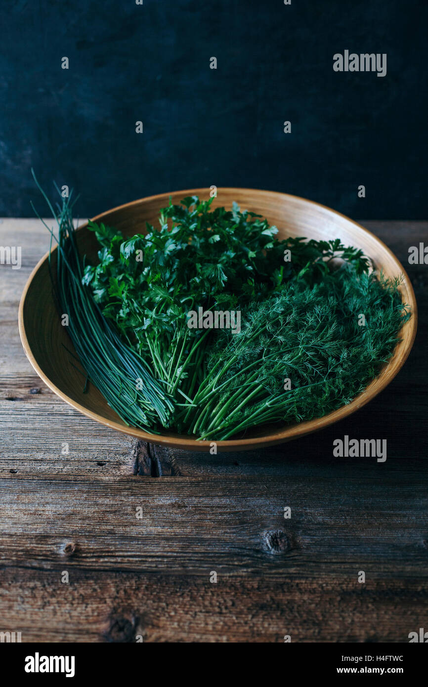 Parsley, chives and dill in a wooden bowl Stock Photo