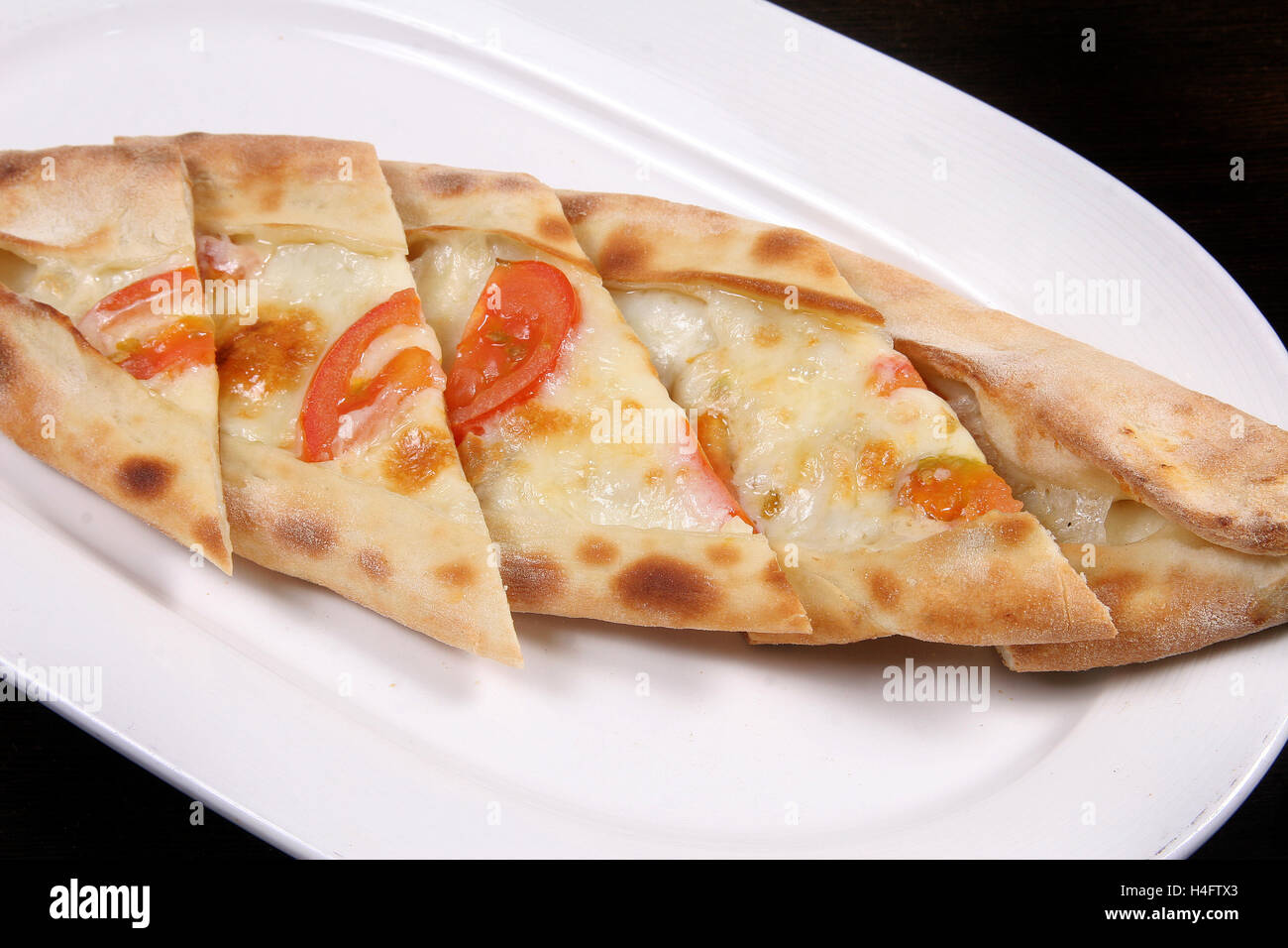 Turkish pizza (pide) tomatoes and cheddar cheese Stock Photo